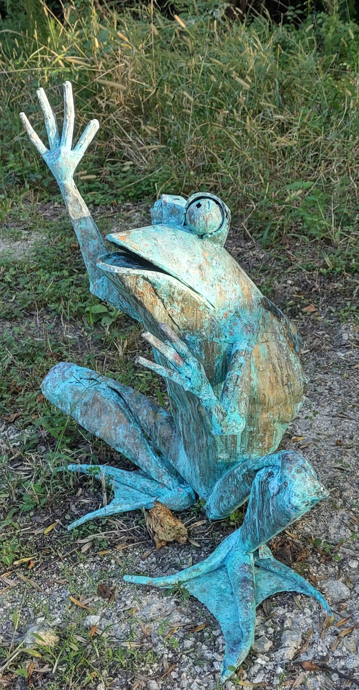 Child size squat frog with legs, arms up, preparing to jump or catch something