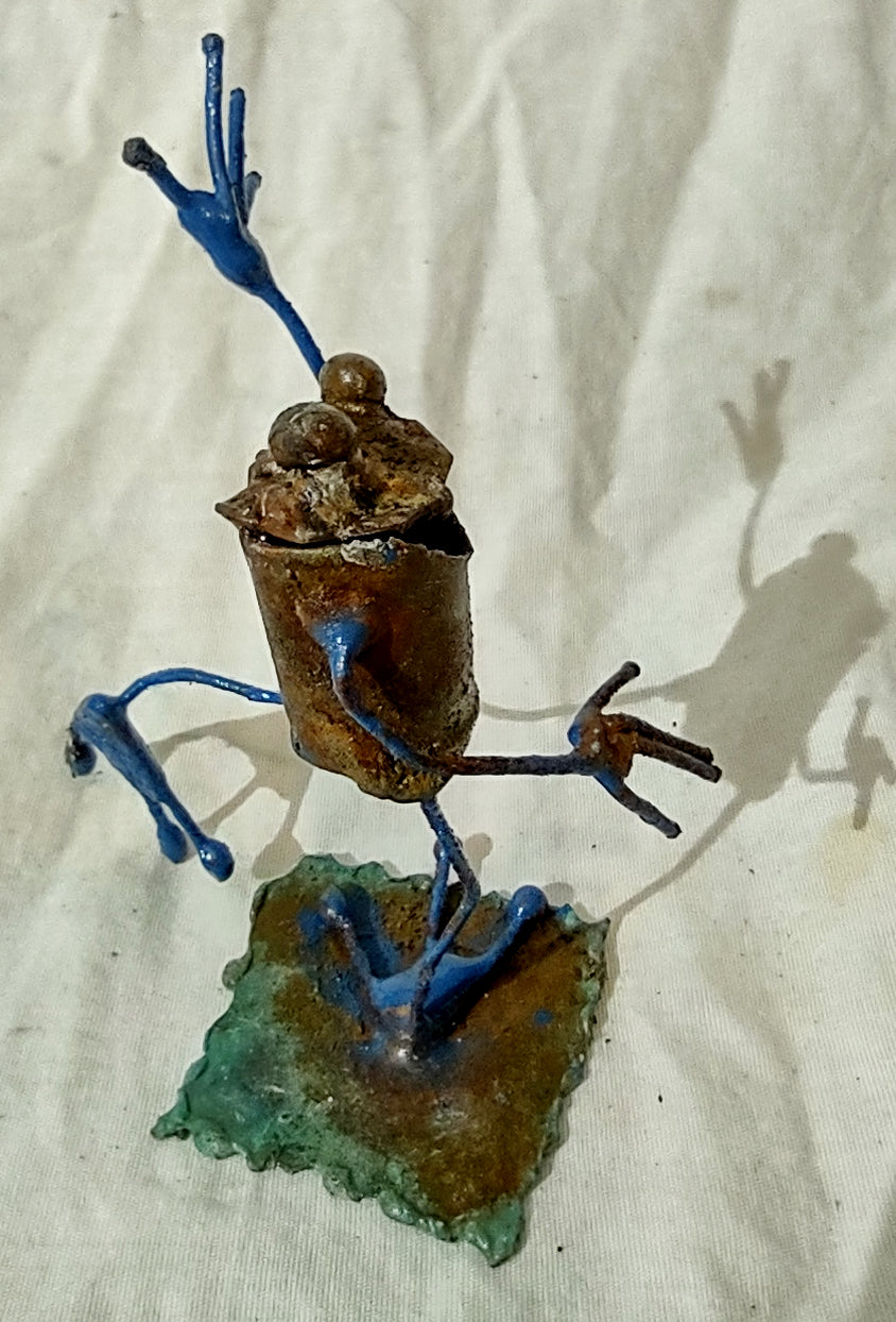 Tiny frog sculpture waving.