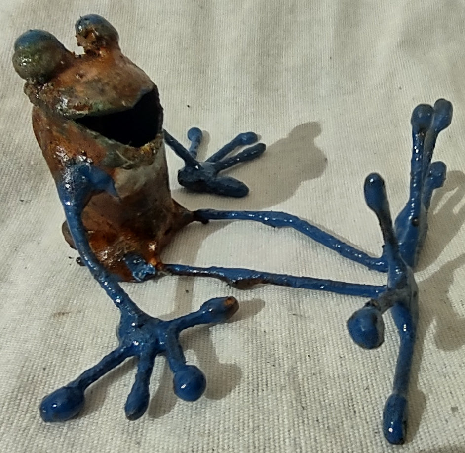 Tiny copper frog seated legs stretched out.