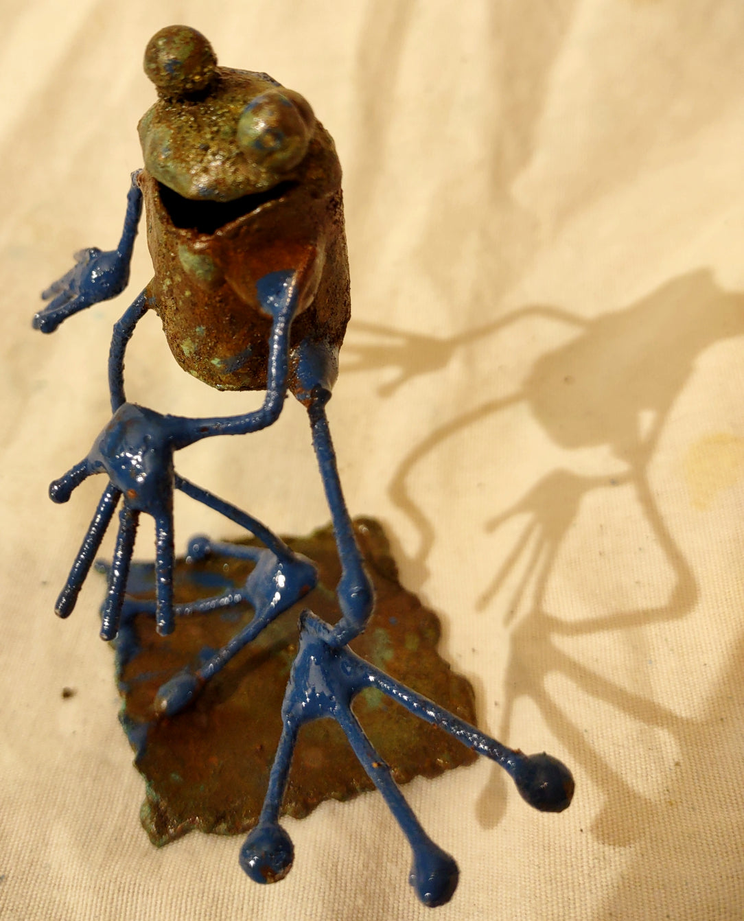 Tiny frog sculpture, taking a step