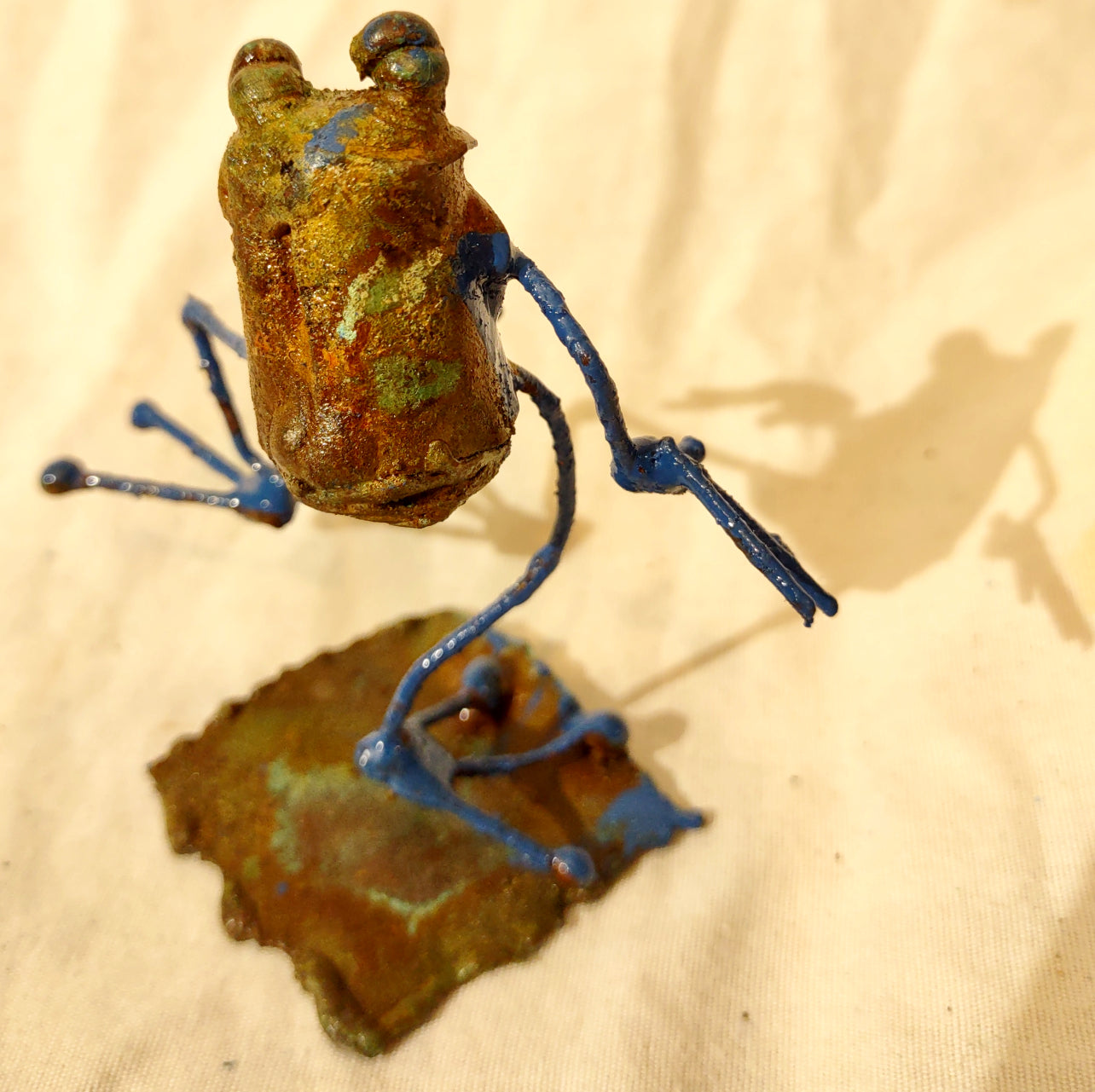 Tiny frog sculpture, taking a step